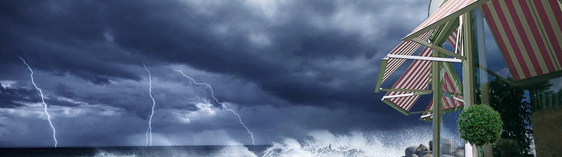Markisen bei startem Sturm und Gewitter am Wasser