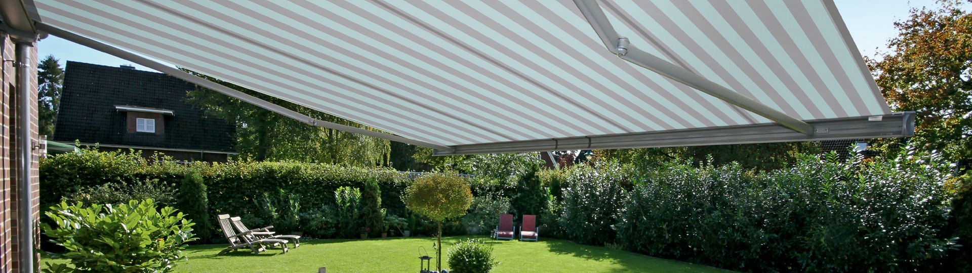 helle gestreifte Markise über Tisch und Stühlen