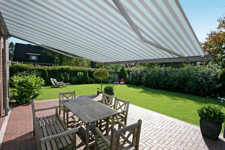 helle gestreifte Markise über Tisch und Stühlen