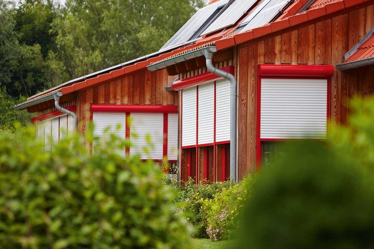 braunes Haus mit rit-weißen Rolläden