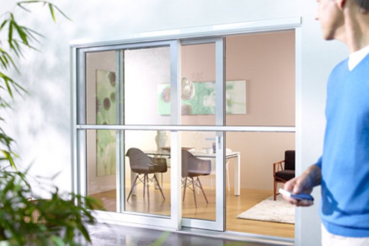 Mann steht vor einer Insektenschutztür