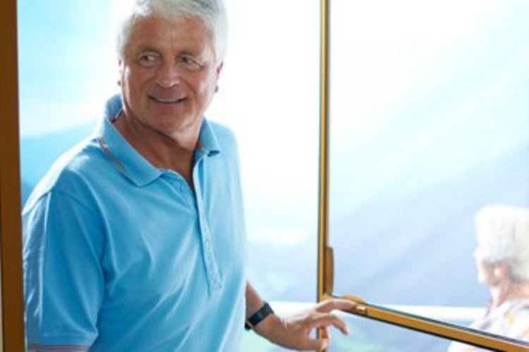 älterer Herr geht lächelnd durch einen Türfliegenschutz