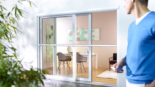 Mann steht vor einer Insektenschutztür